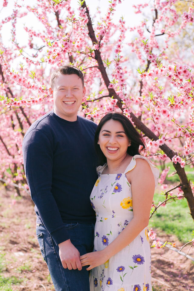 MAn and woman laugh while holding hands in blossom trail