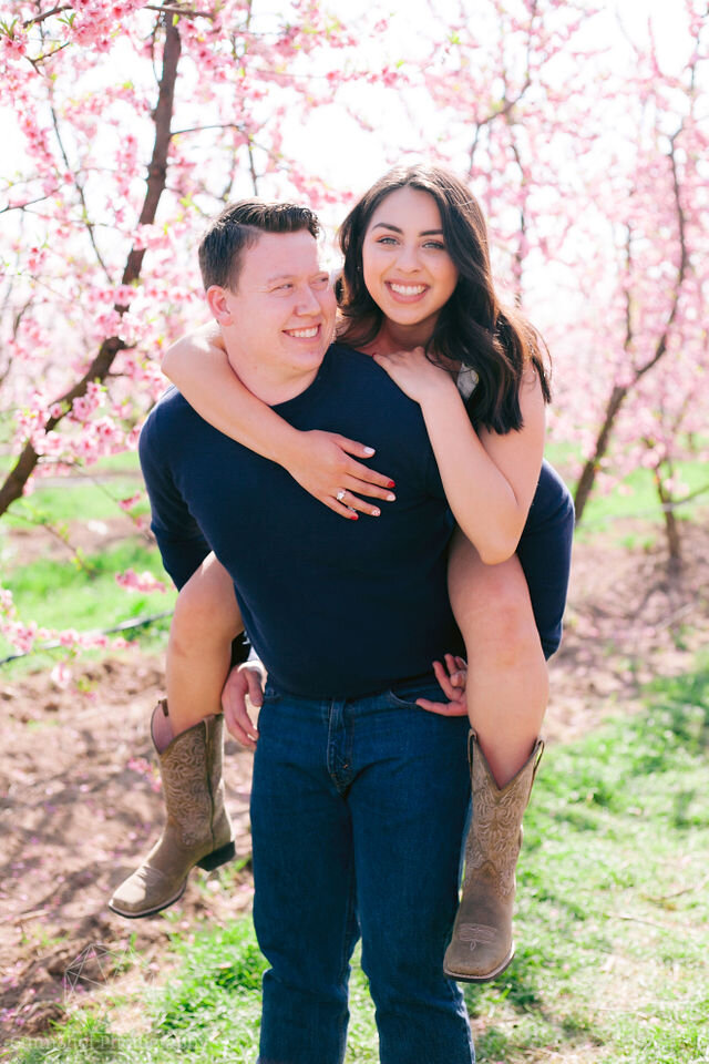 Woman piggyback on man in blue sweater and jeans
