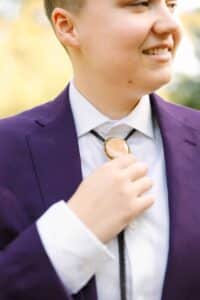 Photo of bride in purple suit and bolo tie. 