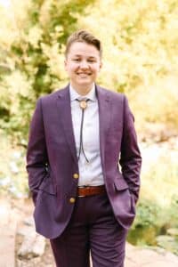 Photo of lesbian bride in purple suit with bolo tie. Suit is made from Indochino
