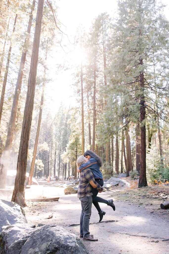 Couple embracing at lower Yosemite falls after yosemite proposal in Yosemite National Park 