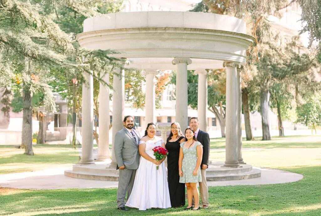 Family portrait after Fresno Courthouse wedding Bride and groom posing with family in front of Fresno Courthouse rotunda after their courthouse wedding