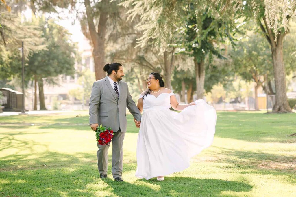 Bride and groom posing with family in front of Fresno Courthouse rotunda after their courthouse wedding