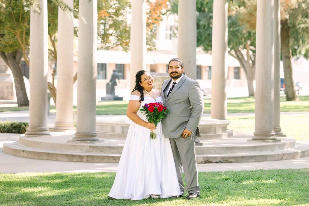 Bride and groom posing with family in front of Fresno Courthouse rotunda after their courthouse wedding