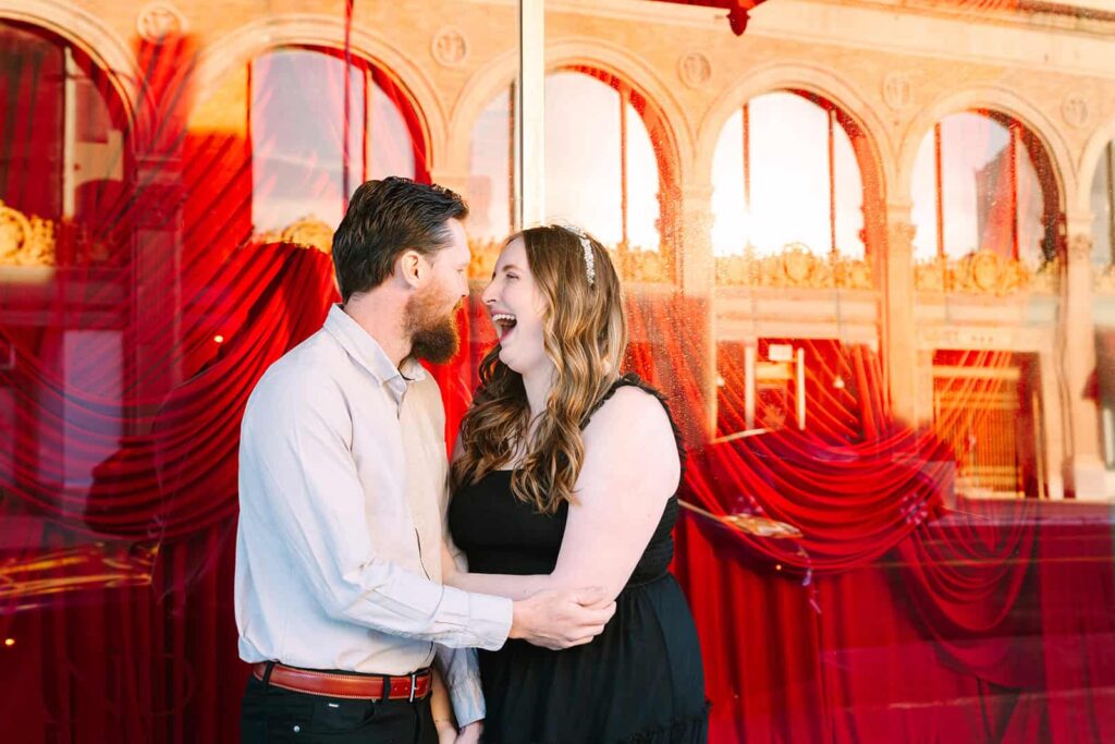 Couple laughing in red window reflections after Fresno courthouse wedding Courthouse wedding couple laughing together in front of red window reflections in Fresno