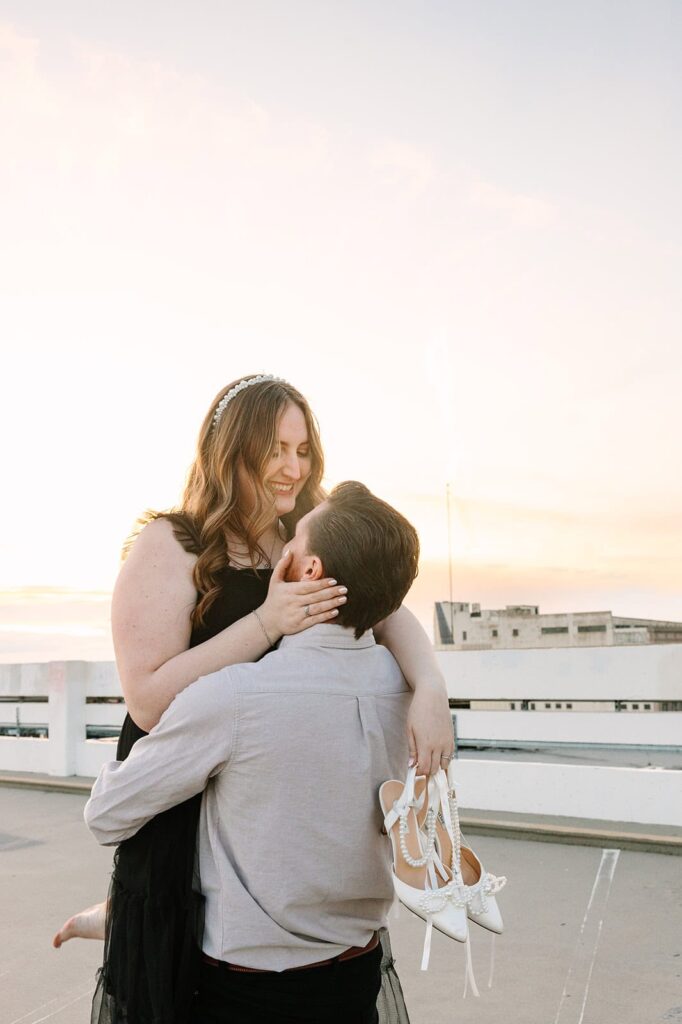 Romantic lift on Fresno rooftop after courthouse wedding Groom lifting bride on rooftop with Fresno skyline in the background after courthouse wedding