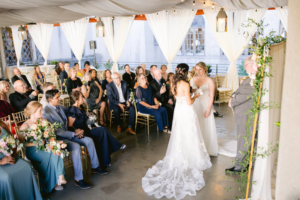 Ceremony moment at a Berkley City Club wedding as two brides stand together before their guests during a lesbian wedding photographed by Michelle Gunn Photo.