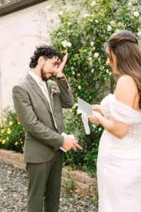 Groom adjusting glasses with emotion as he listens to his bride during their Fresno wedding vows