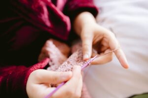 Close-up of wedding morning detail showing hands knitting in a cozy robe