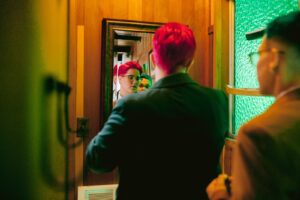 Lighthearted moment between couple during wedding prep in Fresno bathroom