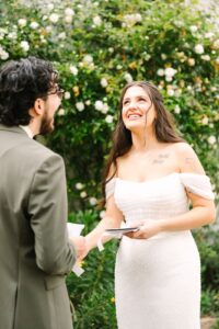 Bride smiling and looking up while reading her vows during an emotional Fresno wedding ceremony