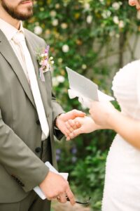 Close-up of bride and groom holding hands while exchanging private vows at their Fresno wedding