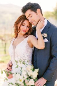 Emotional moment between bride and groom during their Fresno wedding, captured with eyes closed and embracing