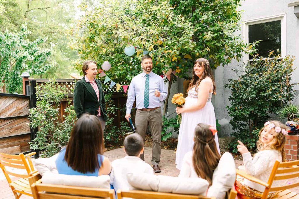 Couple standing together during an intimate front yard ceremony at their Porchfest Fresno wedding in the Tower District.