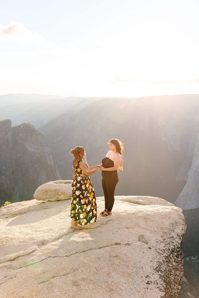 Queer couple watching sunset at Taft Point Yosemite after proposal