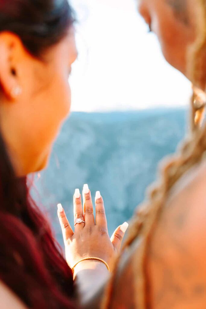 Queer couple watching sunset at Taft Point Yosemite after proposal