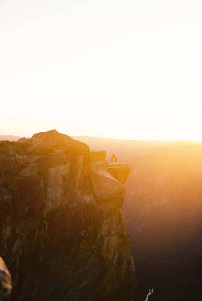 Queer couple watching sunset at Taft Point Yosemite after proposal