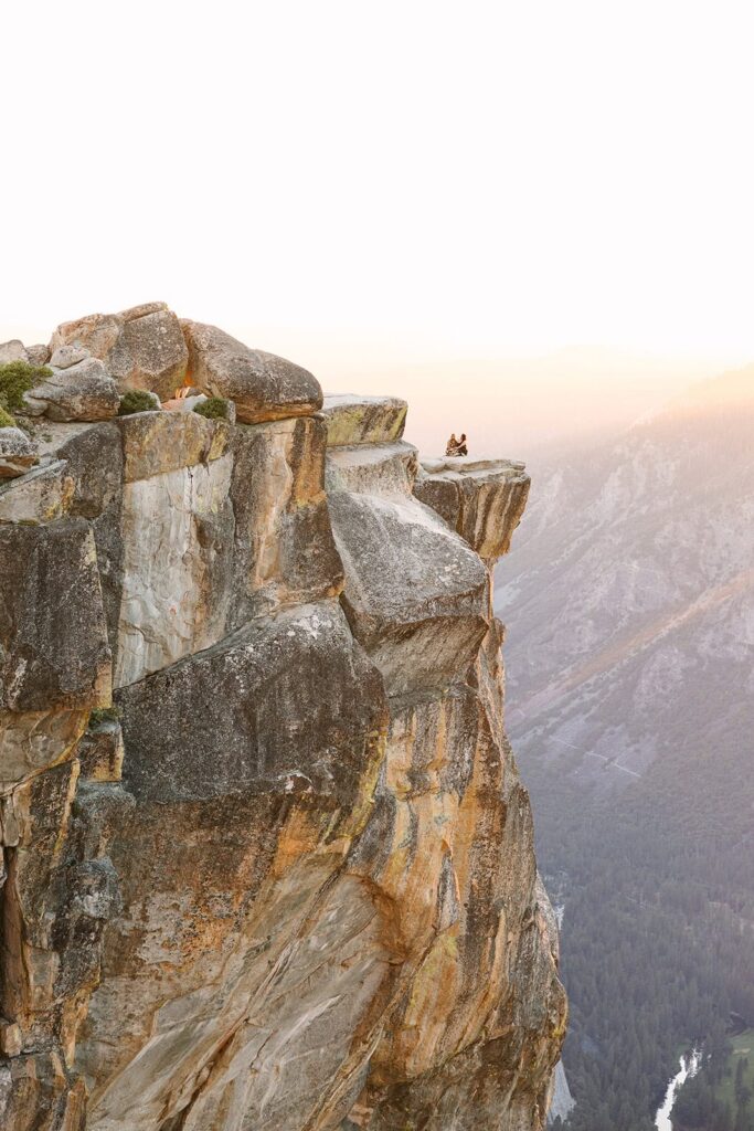 Queer couple watching sunset at Taft Point Yosemite after proposal