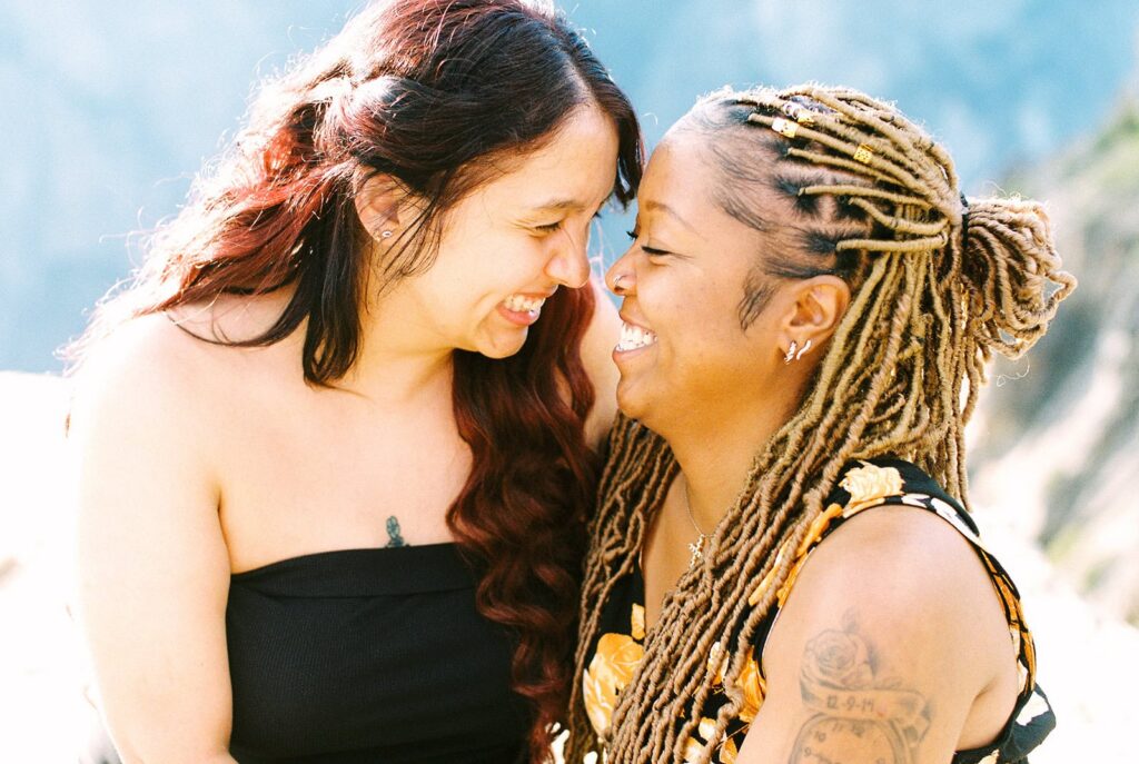 Queer couple watching sunset at Taft Point Yosemite after proposal